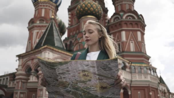 Turista loira atraente olhando para o mapa de pé perto de Kremlin, Rússia verão — Vídeo de Stock