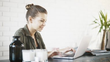 Evde bir dizüstü bilgisayar ile çalışan bir genç kadın Yöneticisi