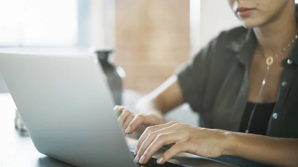 Eine niedliche, ernsthafte weiße Frau arbeitet mit einem Laptop — Stockfoto