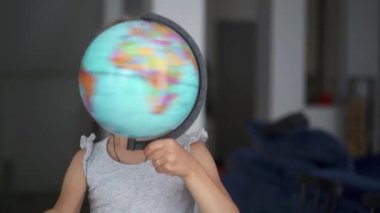 Tanınmayan küçük kız bir küre döne döne