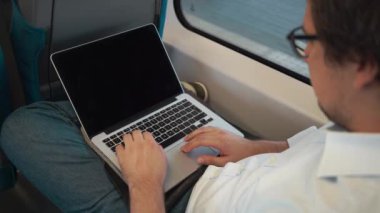 Genç işadamı trende çalışmak için yolda onun laptop kullanma