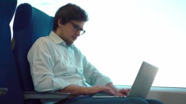 Çalışmak için bir tren sürme onun dizüstü bilgisayarda çalışan genç Yöneticisi