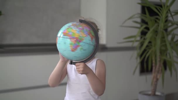 Felismerhetetlen kislány örvénylő a globe at home lassú mozgás — Stock videók