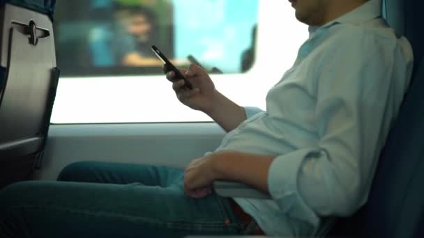 Nie do poznania młody biznesmen SMS-y podczas jazdy pociągu — Wideo stockowe