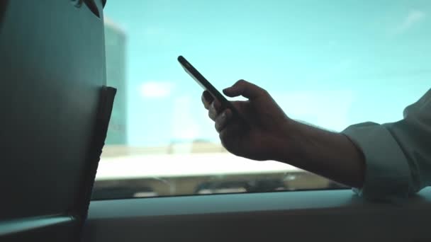 Zakenman websurfen met zijn smartphone tijdens het rijden van een trein — Stockvideo