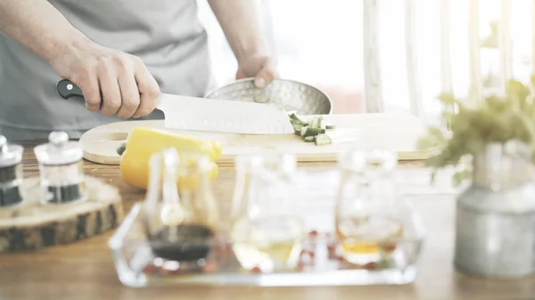 Ręce mężczyzn kuchenki jest wprowadzenie pokrojone ogórki do miski — Zdjęcie stockowe