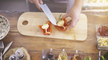 Erkek el bir kırmızı biber yemek bir gemide Dilimleme