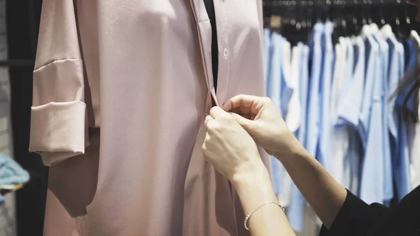 Un gros plan des mains blanches féminines boutonnant un manteau rose — Photo