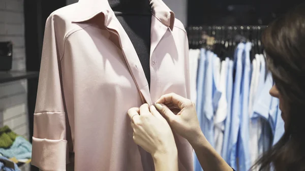 Un gros plan des mains blanches féminines boutonnant un manteau rose — Photo