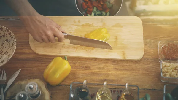 Manliga händer sätter gul paprika i en skål — Stockfoto