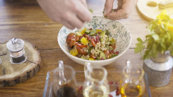 Manliga chef händer lägga persilja till en Salladsskål — Stockfoto