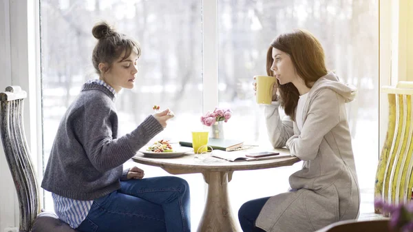 Dos amigas se reúnen en un café para comer — Foto de Stock