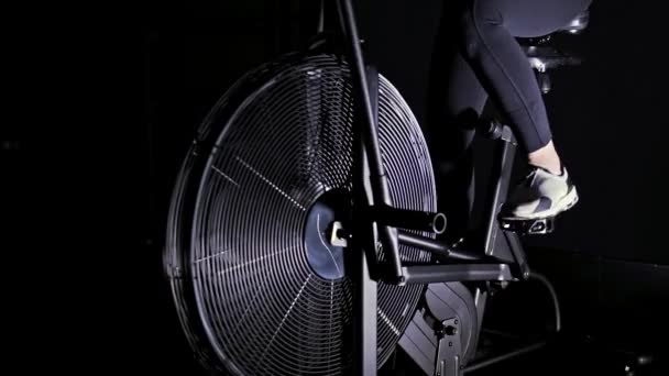 Kvinna s ben i vita sneakers på en cykel maskin i en gym, långsamma mo panorera — Stockvideo