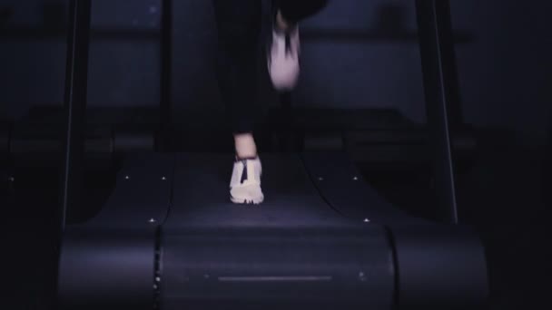 Jambes de femme en baskets blanches et leggings noirs sur tapis roulant — Video