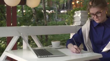 Hippi kız bardaklarda kahve içme ve yaz kafede yazma