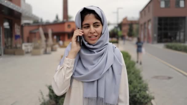 Attraente giovane donna in hijab che parla al telefono per strada — Video Stock