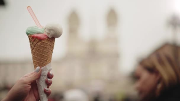 Mano de mujer sosteniendo un helado contra la borrosa Piazza di Spagna en Roma — Vídeos de Stock