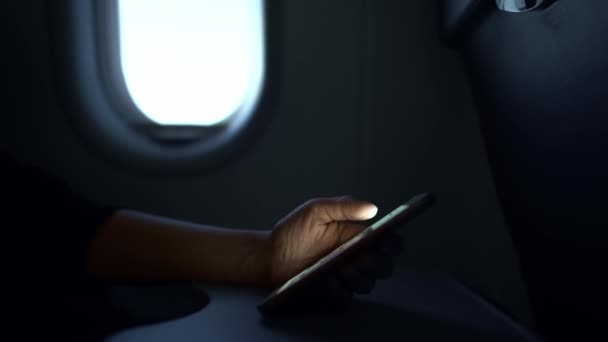 Рука женщины со смартфоном в самолете — стоковое видео