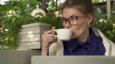 Hippi kız bardaklarda laptopunu pan atış yakınındaki yaz kafede kahve içme