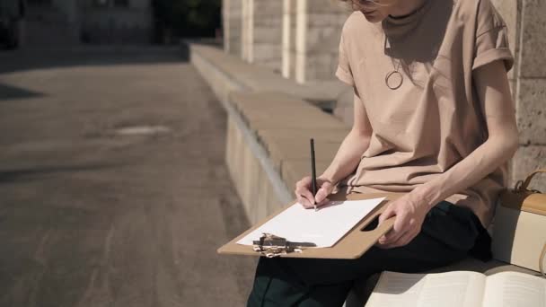 Jeune femme méconnaissable étudiant dehors un jour d'été — Video