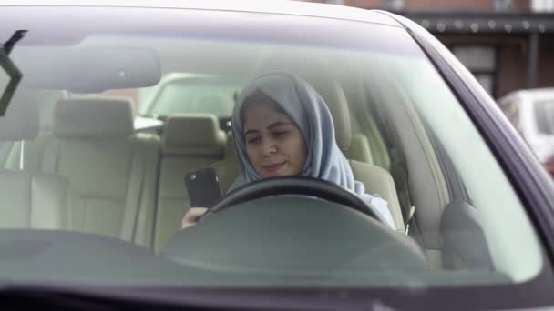 Mulher bonita em hijab web surf em seu carro — Vídeo de Stock