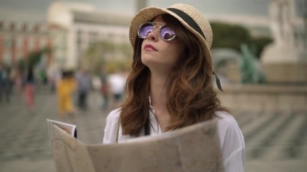 Joven turista caucásico con el pelo oscuro de pie con un mapa en Niza, Francia desenfoque — Vídeos de Stock