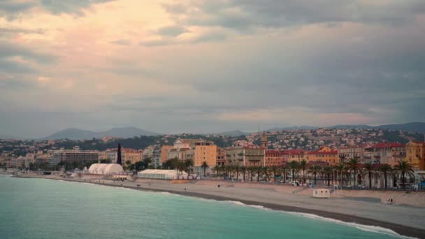 Люди в теплой одежде на пляже Ниццы, Франция на рассвете — стоковое видео