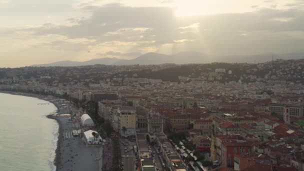 Turisti e gente del posto su una spiaggia vicino al porto turistico di Nizza, Francia, tramonto — Video Stock