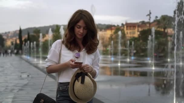 Belos turista menina web surf no telefone andando em francês Nice, primavera — Vídeo de Stock