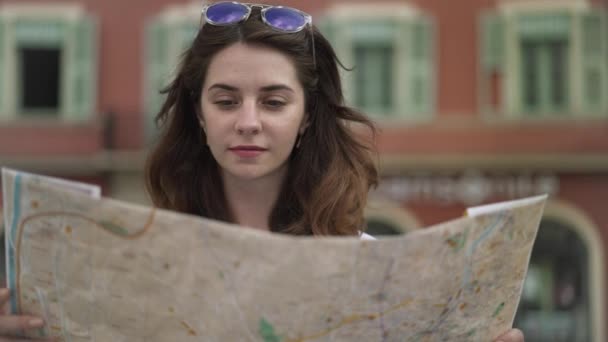 Beautiful tourist girl looking at map in French Nice, pan shot — Stock Video