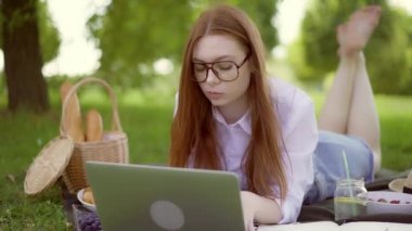 Park içinde laptop ile güzel bir günde okuyan genç kadın merkezli