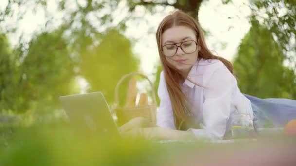 좋은 하루에 공원에서 노트북으로 공부 하는 매력적인 젊은 여자 — 비디오