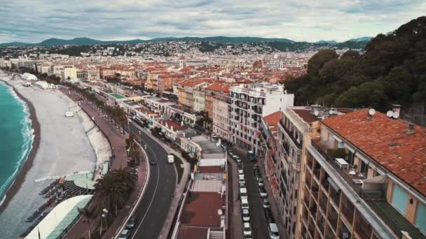 穏やかな海と人々 フランス ニースの海岸を歩きます 高級住宅 車および歩行者 曇り空 観光と豪華なライフ スタイルのコンセプト 右から左へパン リアルタイム — ストック動画