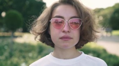 Hipster kadın kahve yaz parkta içki ve sigara pembe güneş gözlüğü