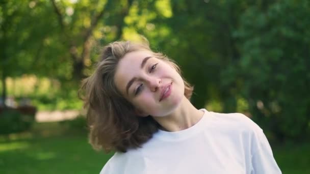 Young woman with short fair hair playing with them in summer park — Stock Video