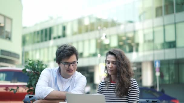 Young business people discussing their project in summer cafe, tilt down — Stock Video