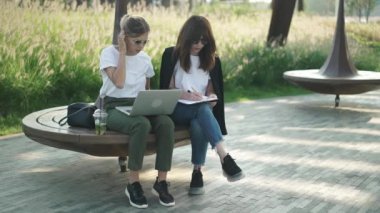 Laptop ile çalışma veya dışında eğitim iki güzel ve akıllı kadın
