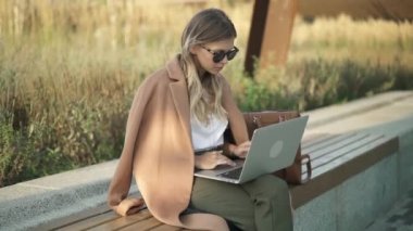 Ciddi genç işkadını dışında onu laptop ile sonbahar gününde çalışma