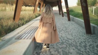 Yürüyüş, etrafında dönen ve gülümseyen güzel sarışın kadının arkadan görünüş