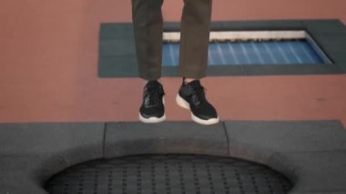 Kadın spor ayakkabı içinde bacaklar ve dışında trambolin üzerinde atlama pantolon