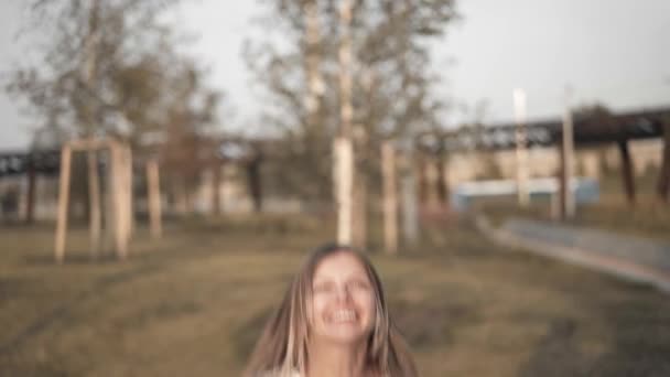 Mujer rubia en camiseta blanca saltando en el trampolín exterior — Vídeos de Stock