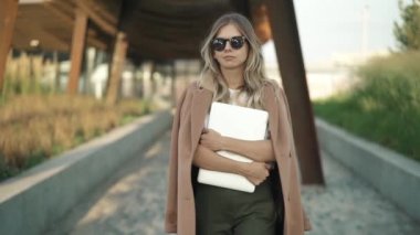 Güzel genç işkadını Park dizüstü bilgisayar ile sonbahar gününde yürüyüş