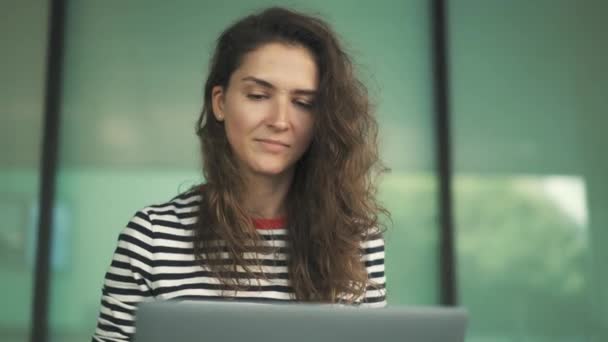 Mladá žena v pruhované tričko pomocí její laptop mimo — Stock video