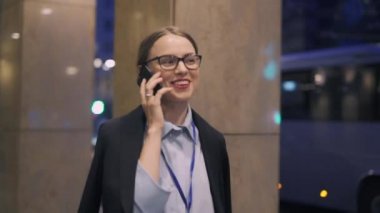 Akşam sokakta yürürken telefonda konuşurken işkadını gülümseyen