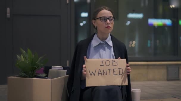 Femme bouleversée assis avec travail en carton signe recherché dans la rue — Video