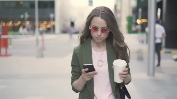 Bella donna d'affari che beve caffè per andare e netto surf a piedi in strada — Video Stock