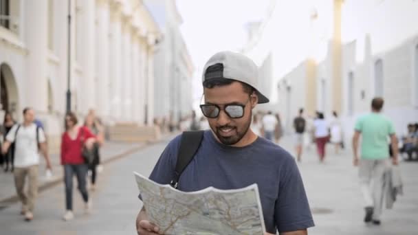 Vista frontal de un joven turista caminando con mapa en la calle Moscú — Vídeos de Stock