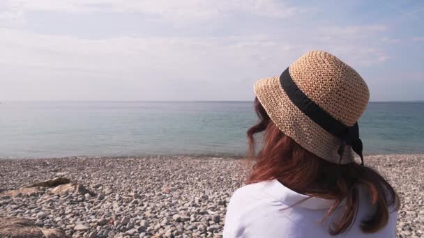 Vrouw op kiezelstrand kijken naar zee, achteraanzicht — Stockvideo