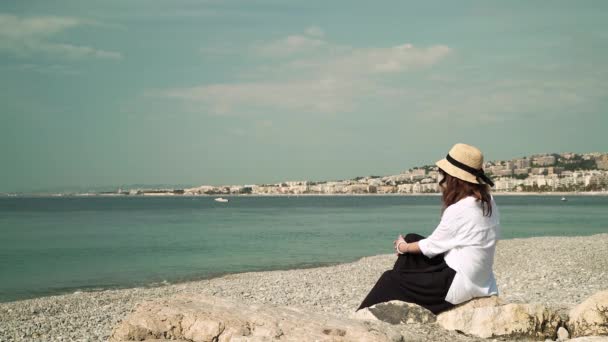 Vrouw op een mooi strand op zoek op zee — Stockvideo