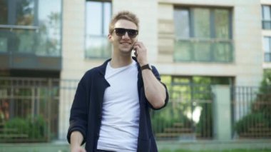 Adam telefonda konuşurken ve zafer jestler yapma güneş gözlüğü